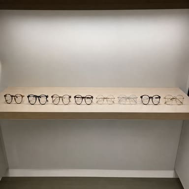 A row of spectacle frames on a display shelf, photographed plainly.