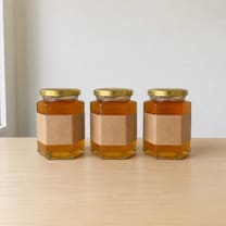 Three jars of honey in a row, photographed plainly.