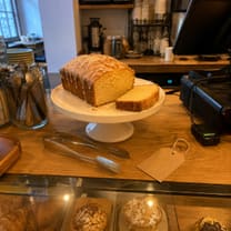 A lemon loaf cake on a café counter, photographed quickly on a phone.