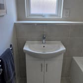 A newly fitted basin and vanity unit, photographed on a phone.