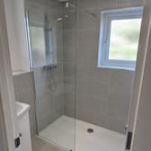 A finished walk-in shower, photographed from the doorway.